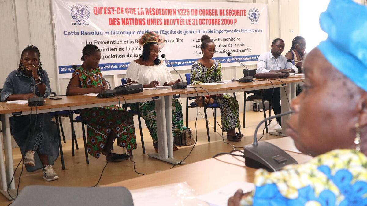 A conference panel addresses an audience.