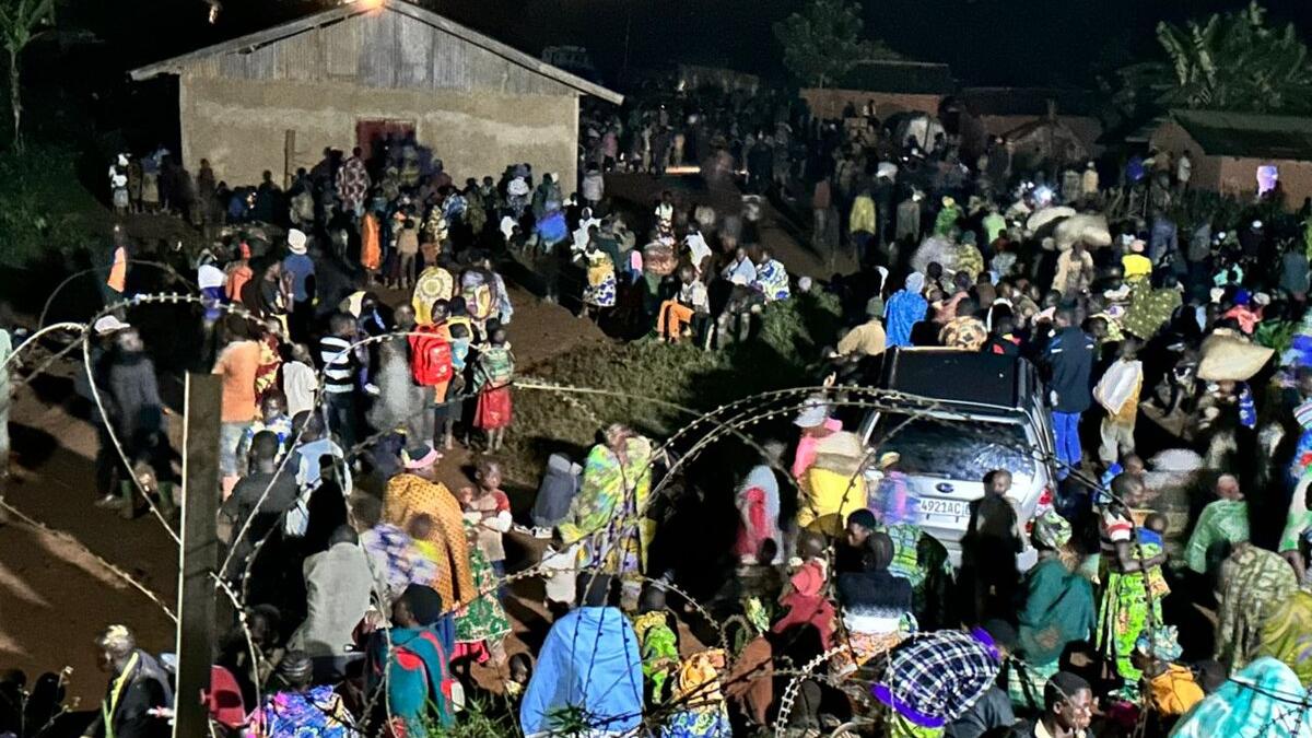 Un groupe de personnes se tient à l'extérieur.