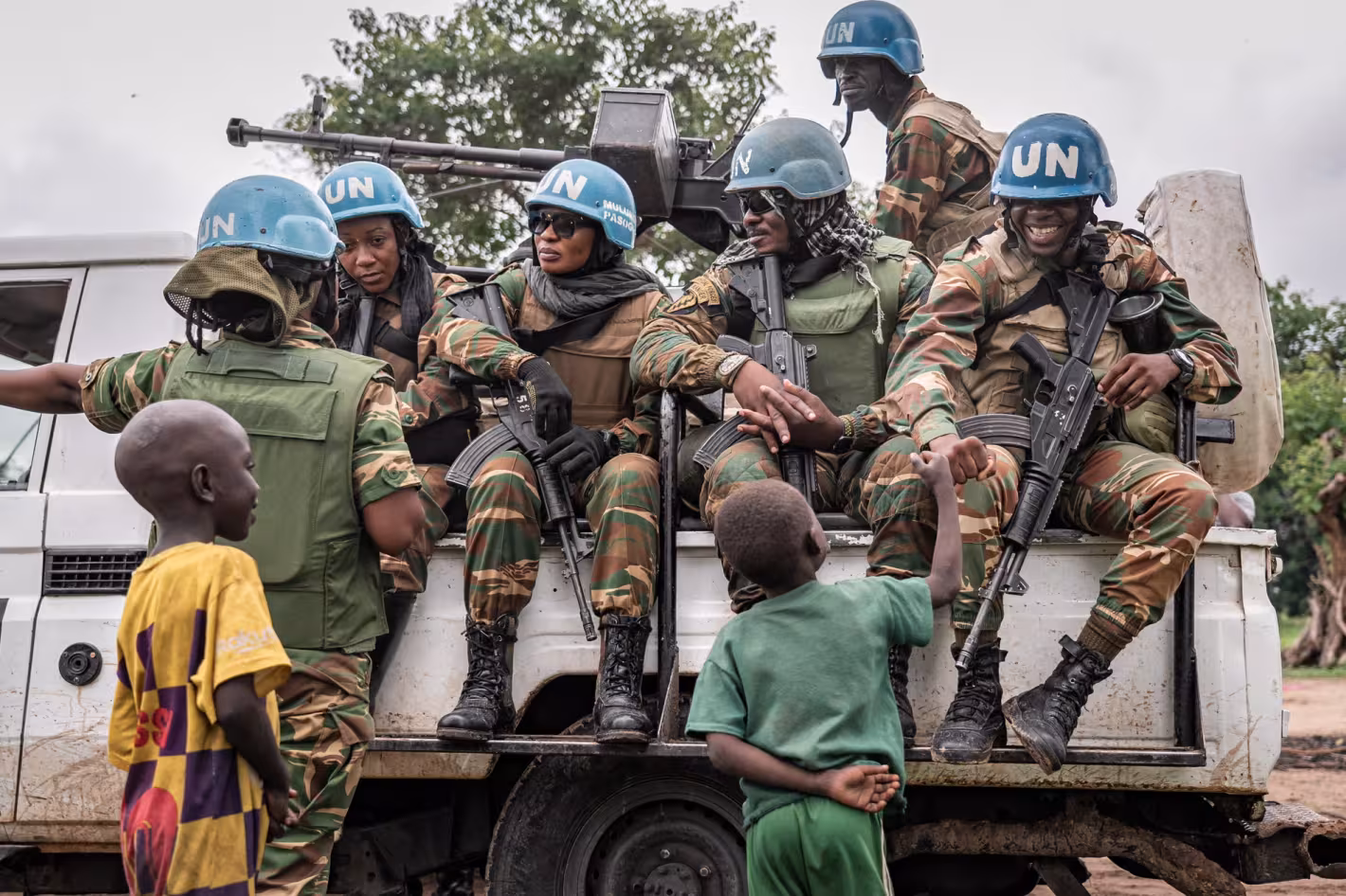 cascos azules, a bordo de un camión de la ONU, interactúan con los niños.