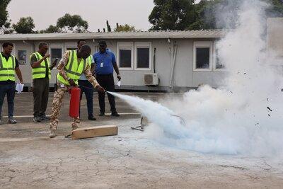 Une personne éteint un incendie.